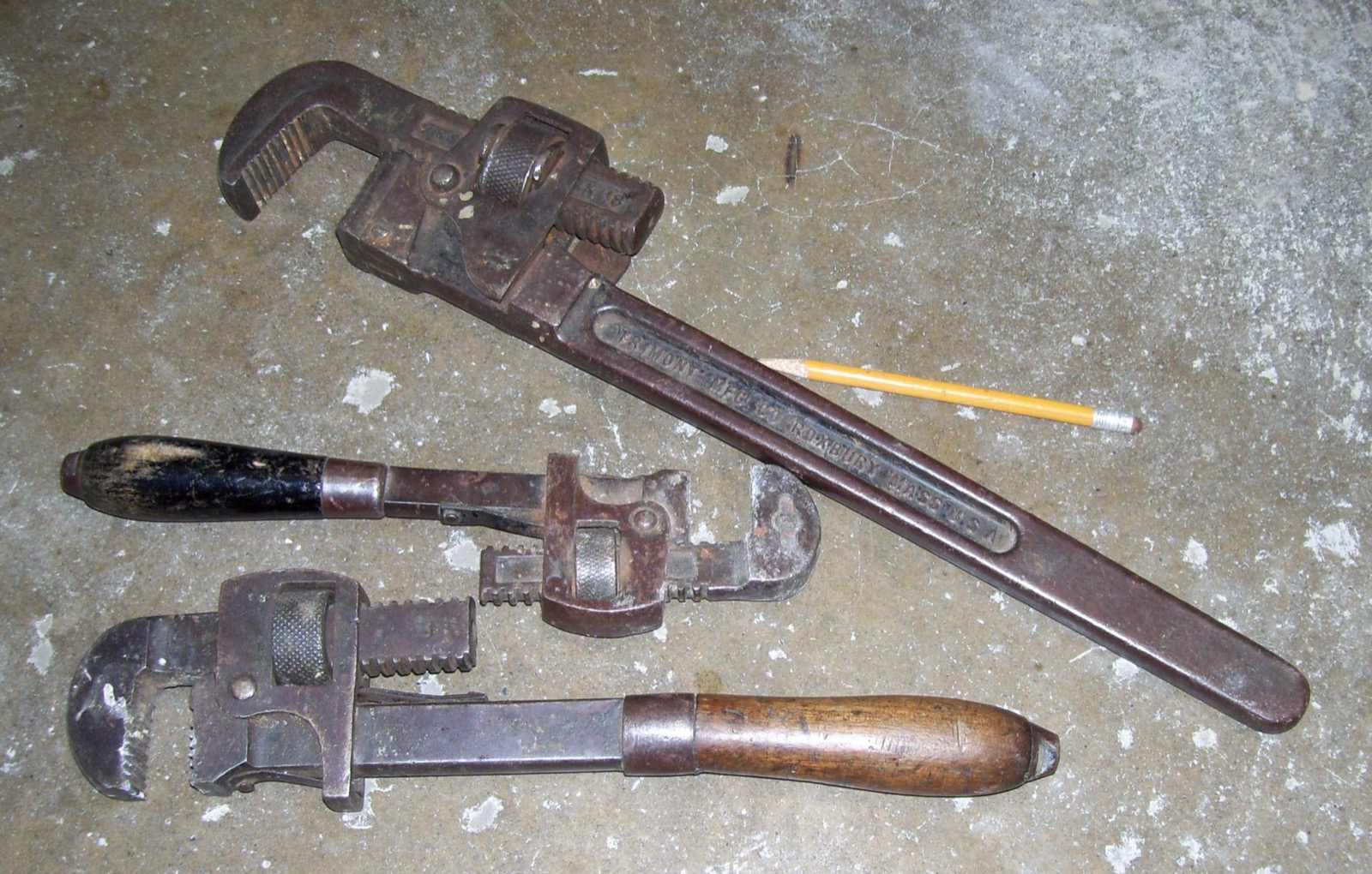 Three pipe wrenches on concrete